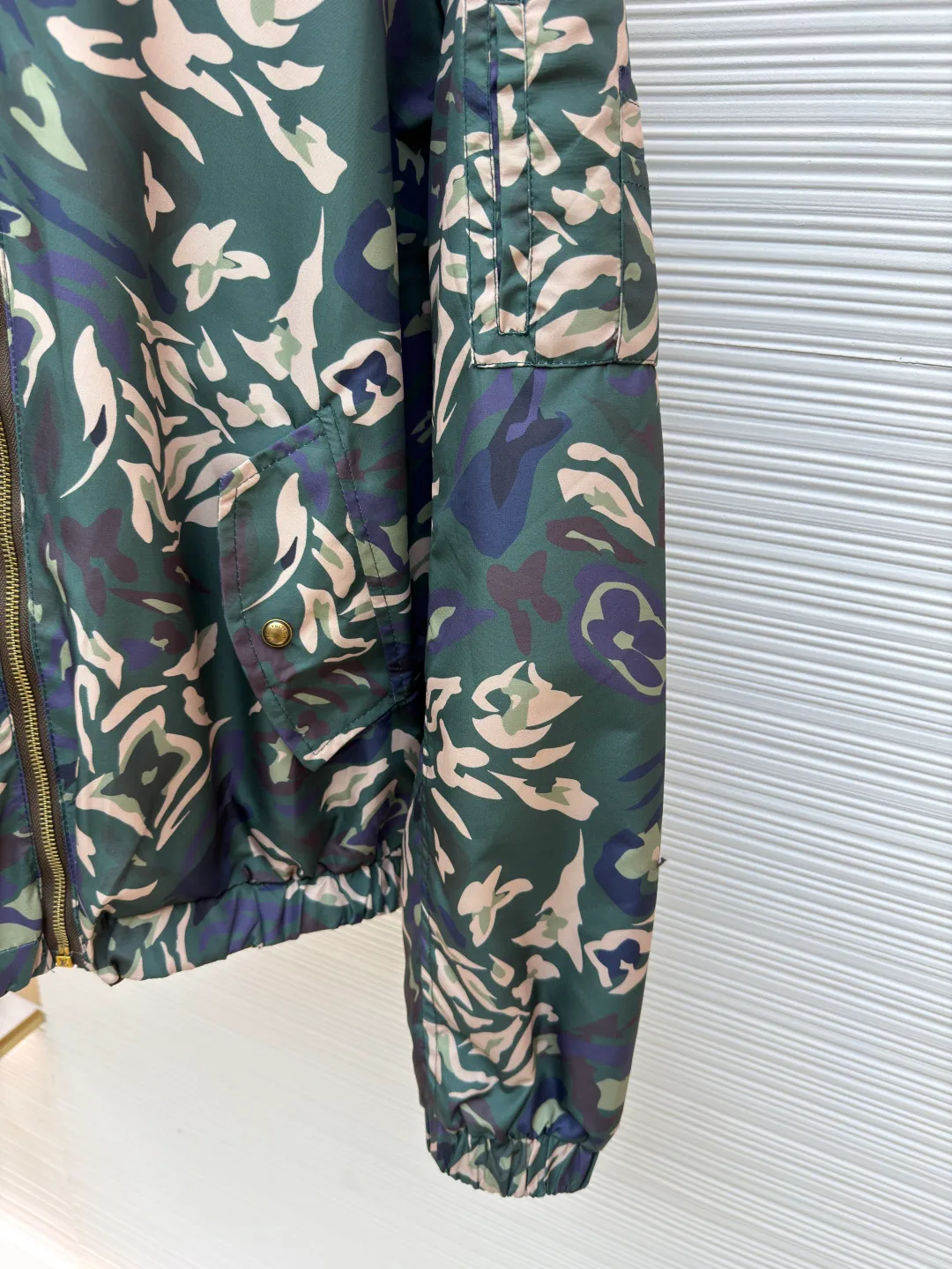 LOUIS VUITTON camouflage printed reversible hooded jacket ●Original version: 26800 purchase and development ●Item number: 1681223-B80 ●Fabric: nylon fabric ●Technology: printing production ●Color: camouflage ●Version: fitted version ●Weight: about 550 grams ●Size: 48-50-52-54 ●Description: This windproof jacket is made of lightweight nylon, 2025 The LV Camo pattern and full-frame Monogram jacquard from the autumn and winter show are decorated on both sides. Multiple pockets reflect functional considerations, and the elastic hood, hem and cuffs complete the overall look. 100% polyester fiber, custom-engraved logo hardware, front camouflage printing, presbyopia printing, reversible design. The overall wiring is straight and delicate, the fabric is comfortable and soft, and the color is consistent without color difference. It can be matched with the same style to create a fashionable look and control various occasions. Customized accessories, complete with three standards, same style for men and women!